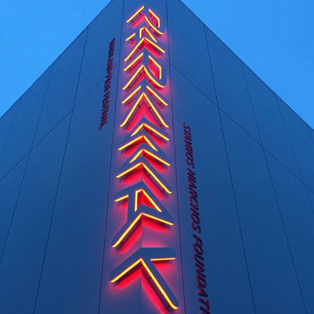 Illuminated 3D corner letter signage integrated into a modern architectural facade