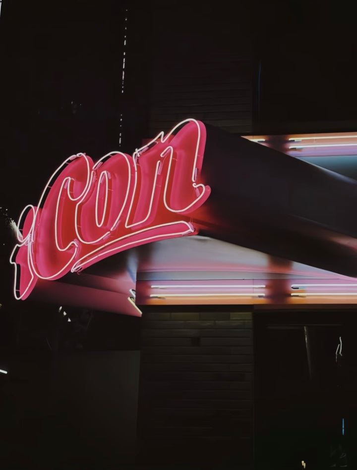 Side view of 3D neon letter signage showing depth and layered construction on a corner installation.