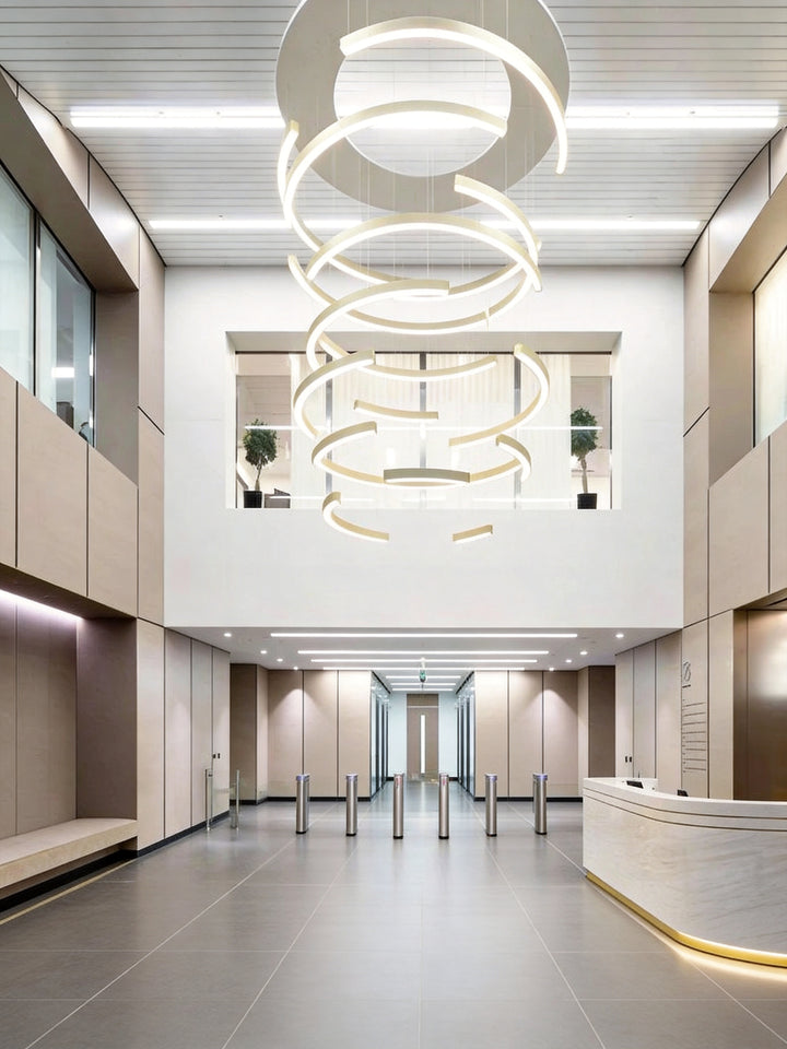 LumiHalf Ring Bespoke Lighting by Lucretia, custom stacked half-ring LED chandelier installation in a double-height commercial building lobby with reception desk