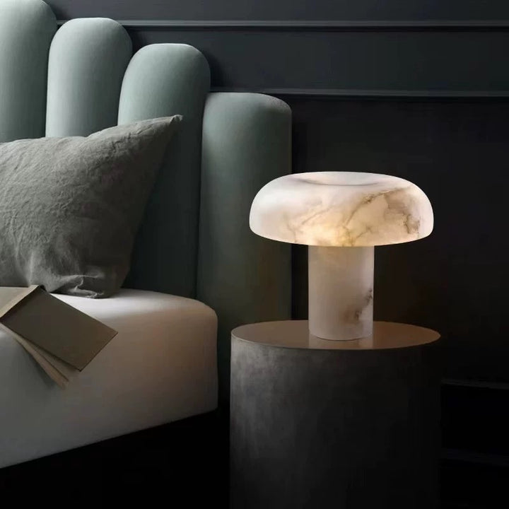 Alabaster bedside table lamp styled in a modern bedroom, providing soft warm ambient lighting for nightstands and cosy interiors.