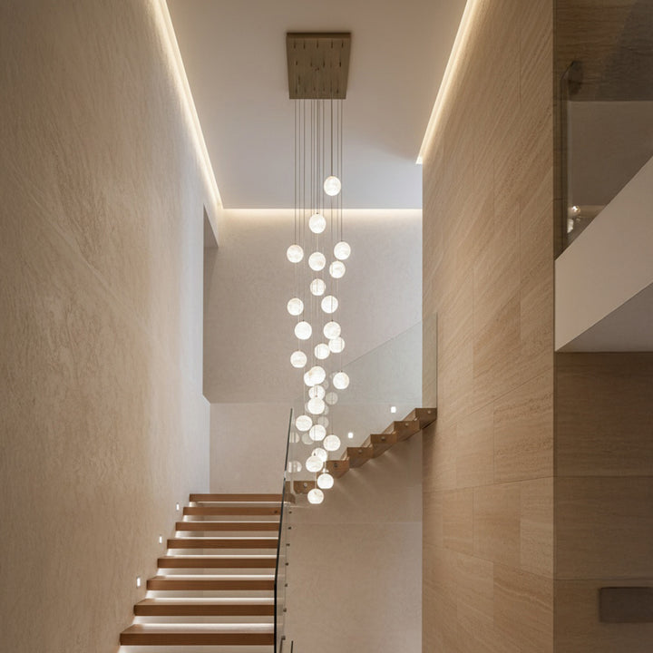 Alabaster multi-drop pendant lighting installed in double-height staircase interior