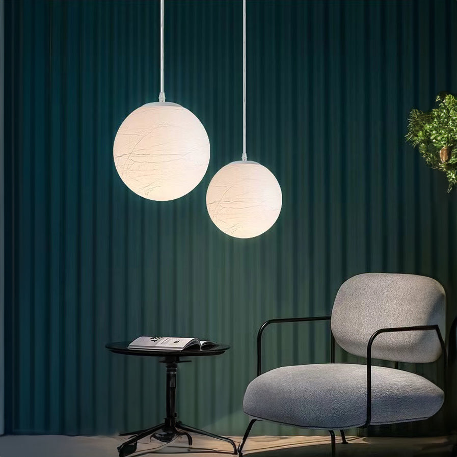 a softly diffused pendant light illuminating a relaxed seating space, adding gentle ambient light and visual calm to the room