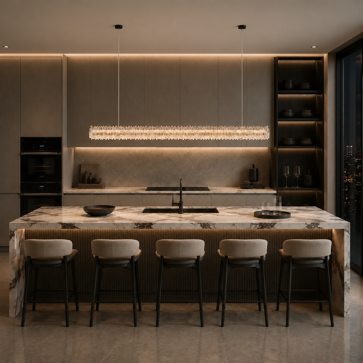 Modern luxury kitchen featuring the Belo Glacia crystal linear pendant light above a stone kitchen island with warm architectural lighting.