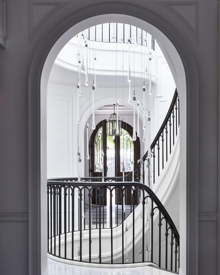 Bijou Custom Void Pendant Light of suspended glass raindrops descending through a stairwell above a grand residential entrance