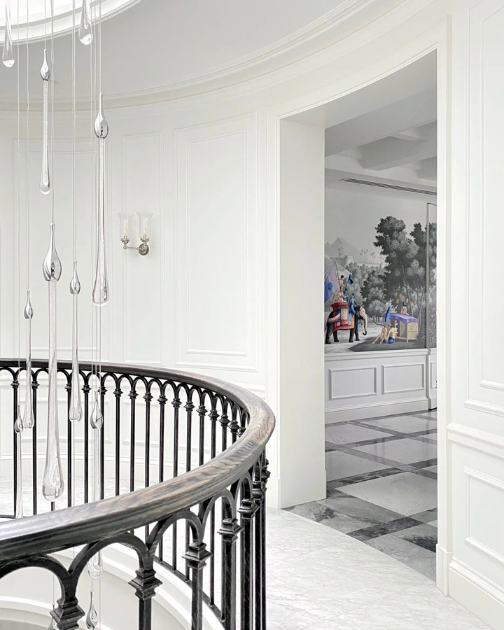 Bijou Custom Void Pendant Light with cascading glass raindrops above a curved black balustrade in a high-end residential stairwell
