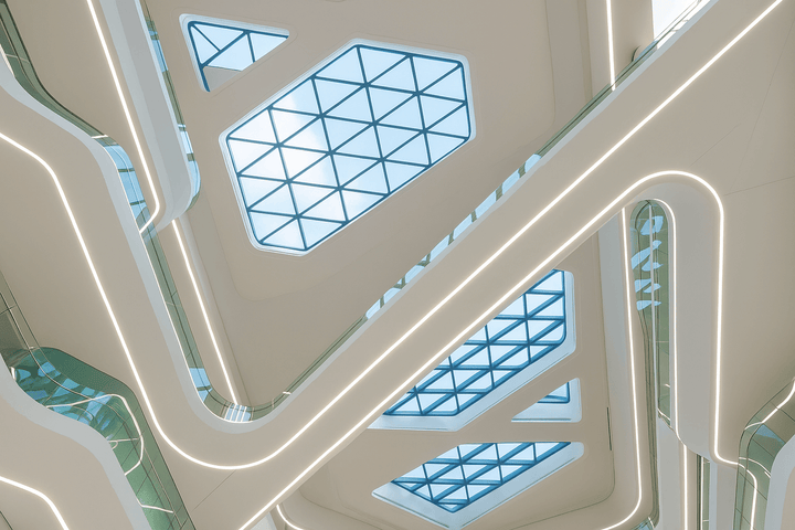Recessed curved LED linear lighting installation in a commercial architectural ceiling with seamless integrated light lines