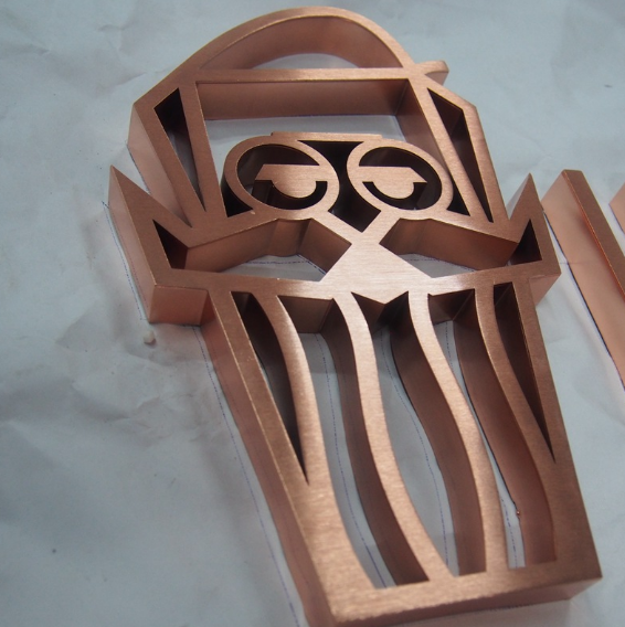 Custom 3D stainless steel channel letter logo with rose gold finish, precision fabricated for commercial branding and architectural signage.