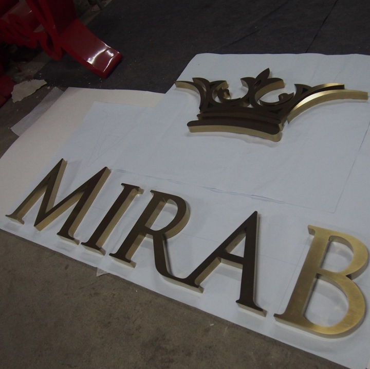 Custom stainless steel channel letter sign with logo detail, designed for commercial storefront and brand signage.