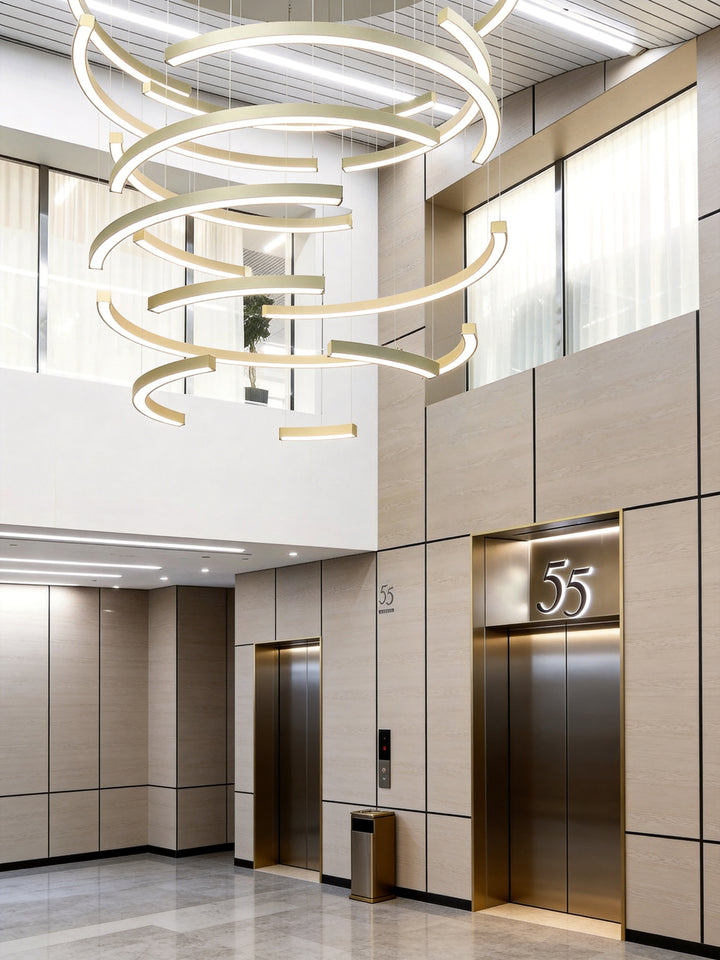 LumiHalf Ring Bespoke Lighting by Lucretia, custom multi-layer half-ring LED chandelier in brushed gold finish installed in a commercial lift lobby void