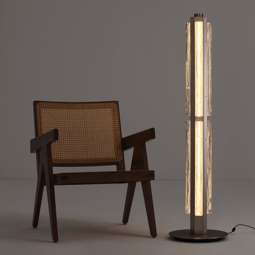 Hand-blown glass floor lamp next to lounge chair, warm ambient lighting for contemporary interiors