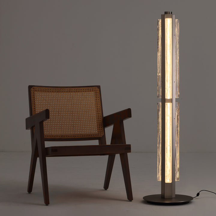 Hand-blown glass floor lamp next to lounge chair, warm ambient lighting for contemporary interiors