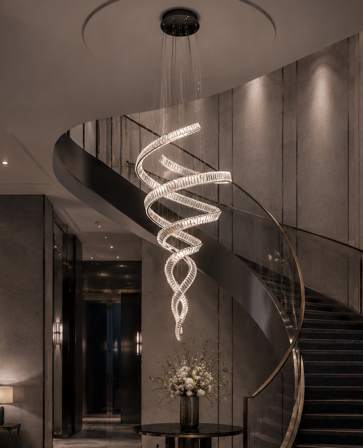 Dual spiral crystal chandelier in a dark luxury hotel staircase void with curved bronze balustrade, dark marble walls and floral display, Pharaoh Tour Double 1950 Chandelier by Lucretia