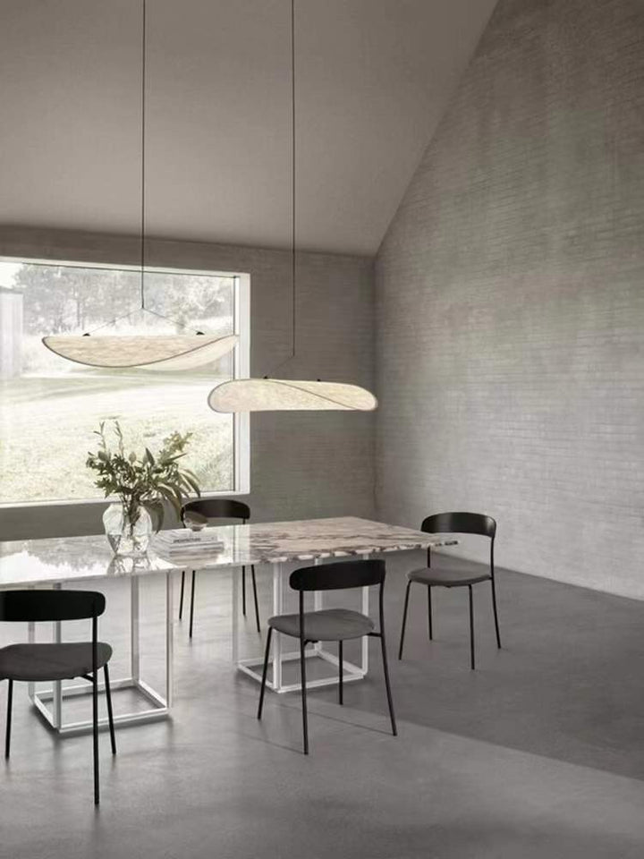 a floating pendant light positioned within an open dining area, delivering gentle ambient light that blends naturally into the space