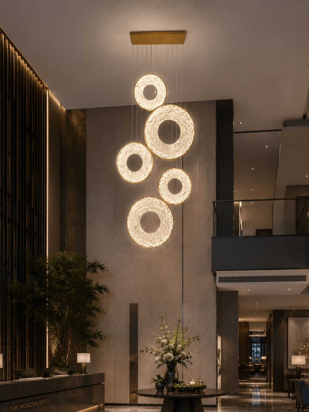Galactic Halo Pendant Light cluster of glowing halo rings in a double-height hotel lobby above the reception and lounge entry