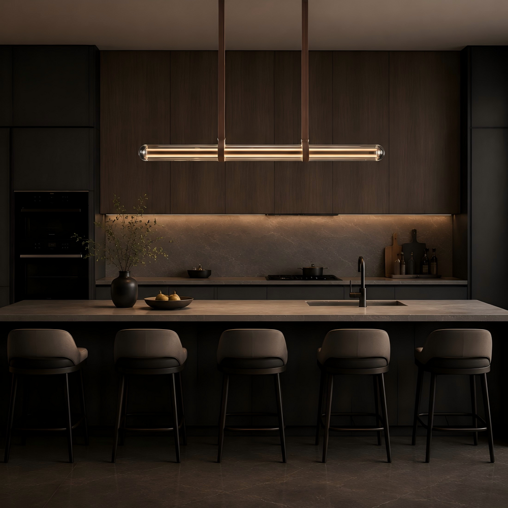 Glass tube linear pendant light over a kitchen island and dining space, contemporary LED suspension light for modern homes, luxury interiors and architectural lighting projects.