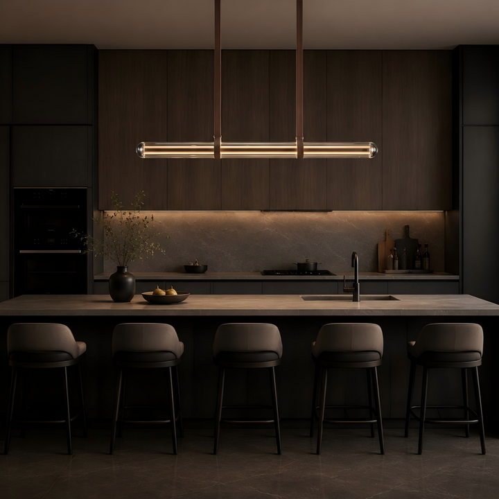 Glass tube linear pendant light over a kitchen island and dining space, contemporary LED suspension light for modern homes, luxury interiors and architectural lighting projects.