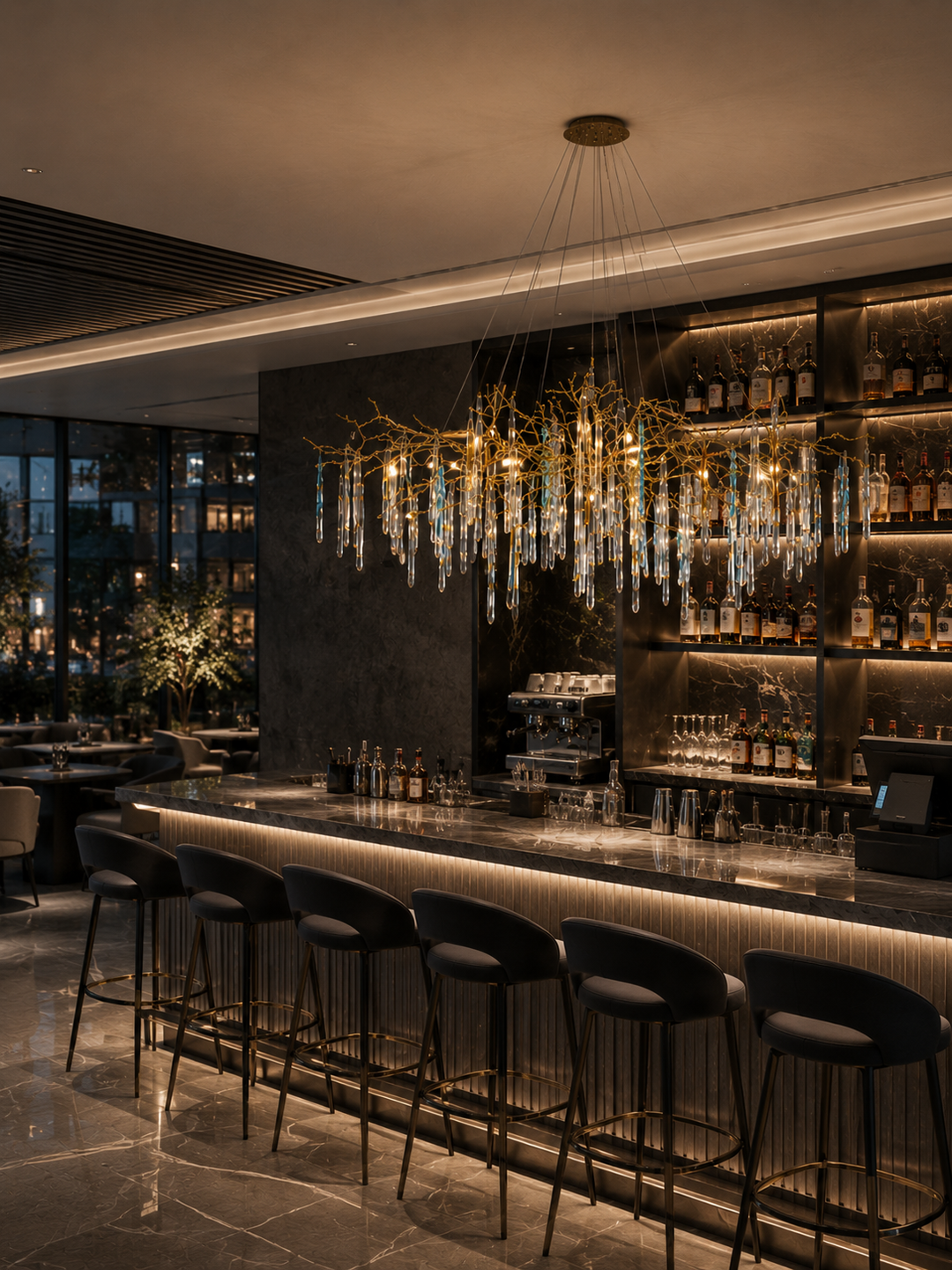 Glazed Icicle Brass Chandelier with brass branch frame and glass icicle drops above a marble cocktail bar with backlit spirit shelves