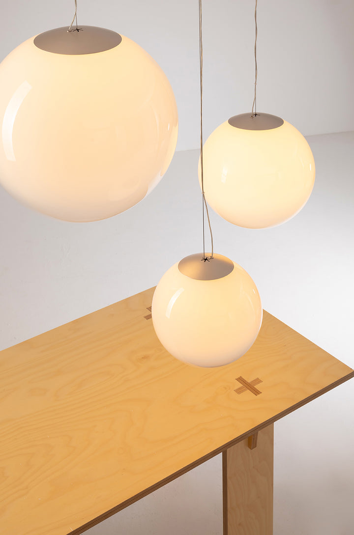 Gradient glass pendant light suspended above a wooden table