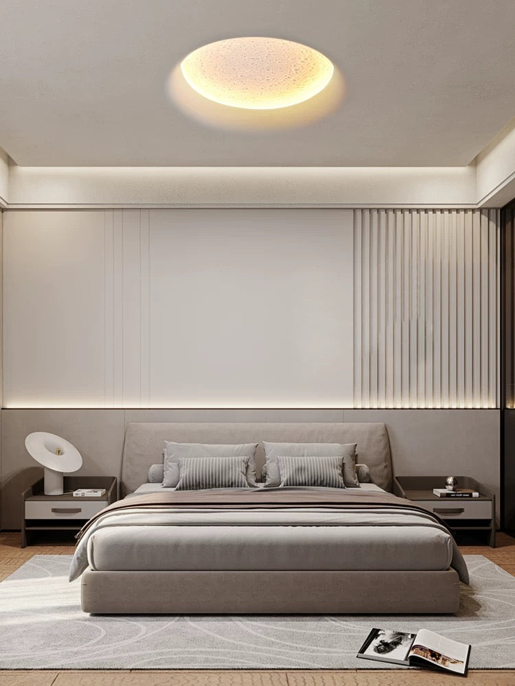 round gypsum LED ceiling light used as a modern flush mount creating warm ambient bedroom lighting