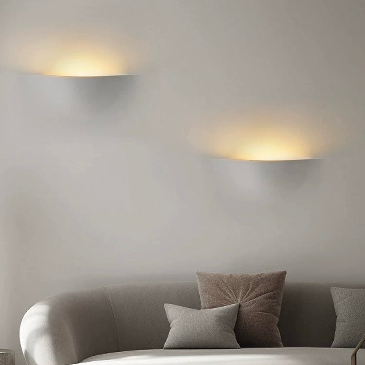 sunrise gypsum LED wall light creating warm ambient wall lighting above a modern living room sofa