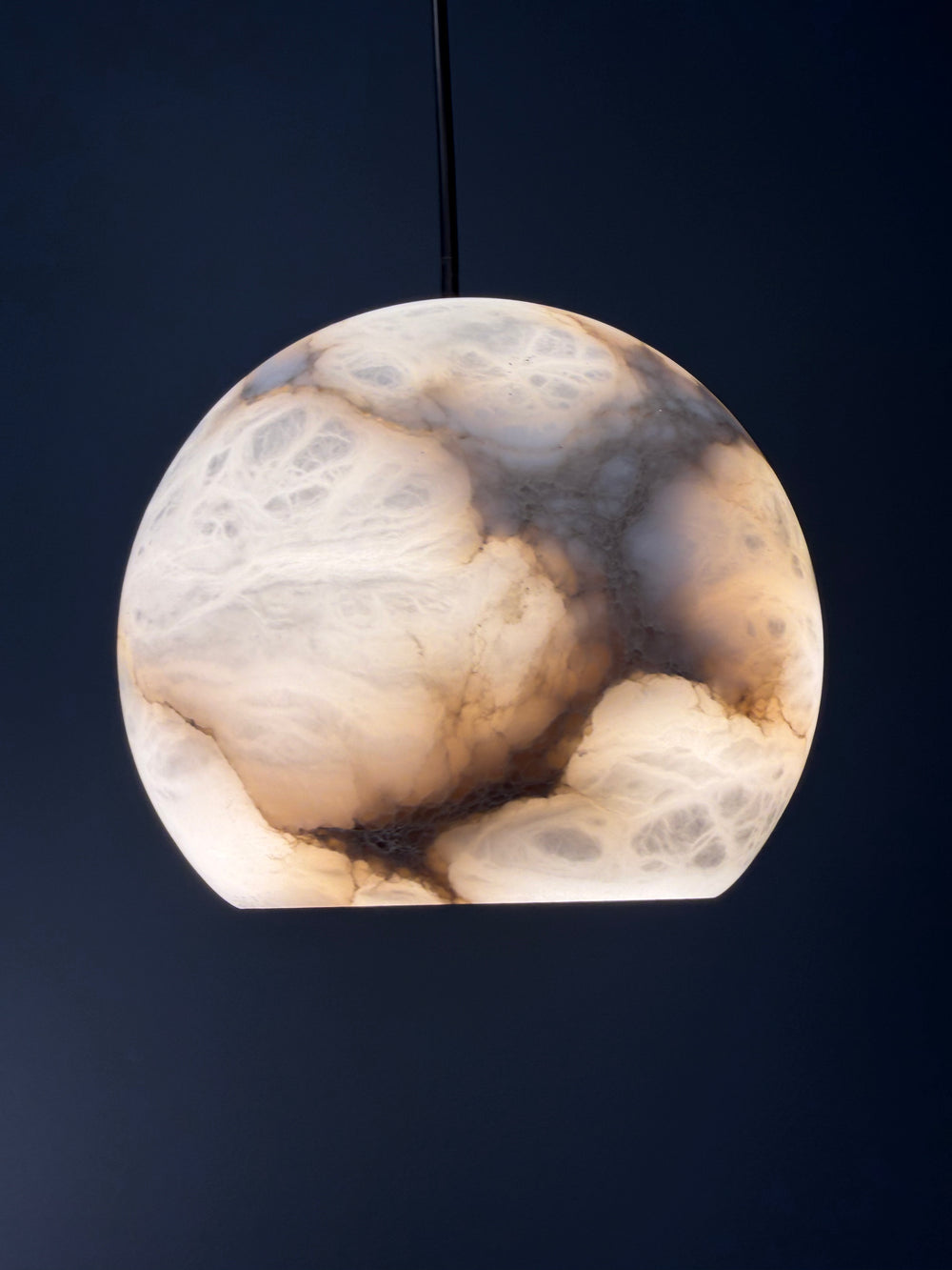 Half Moon natural Spanish alabaster pendant light showing unique stone veining, rounded silhouette and warm illumination