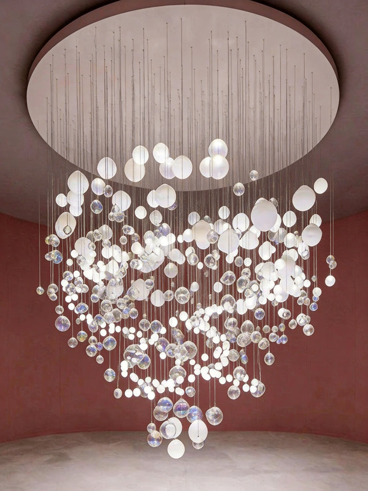 Large-scale hand-blown glass bubble sculptural chandelier suspended from a circular ceiling in a luxury interior with rose pink walls, BubbleGlow Bespoke Lighting by Lucretia