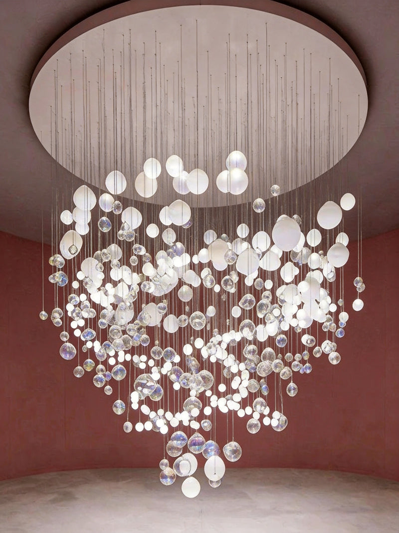 Large-scale hand-blown glass bubble sculptural chandelier suspended from a circular ceiling in a luxury interior with rose pink walls, BubbleGlow Bespoke Lighting by Lucretia