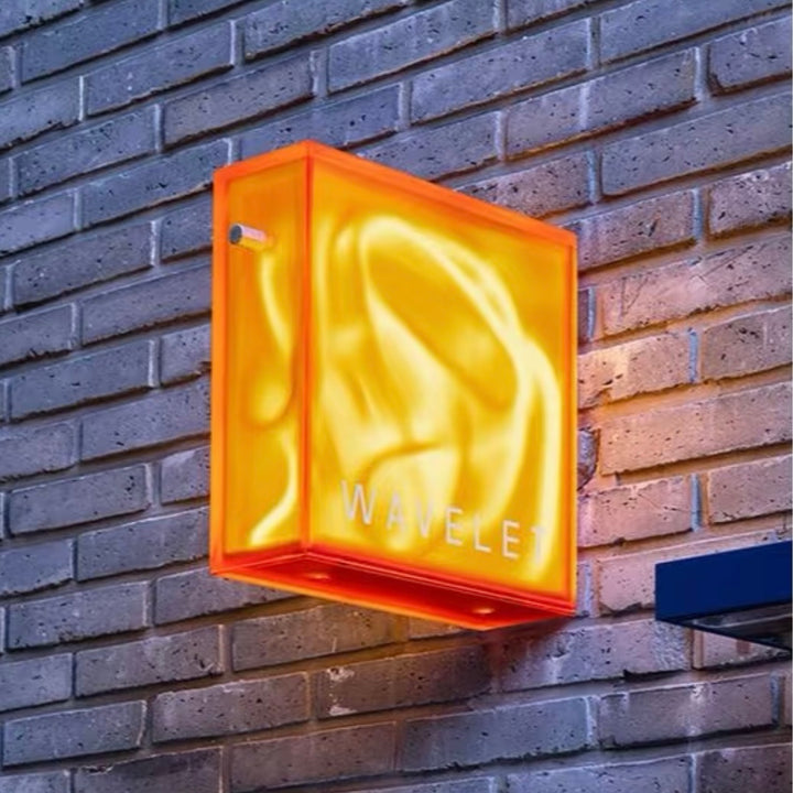 illuminated neon art box with acrylic enclosure mounted on brick wall for retail storefront display
