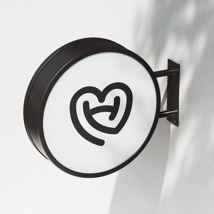 Illuminated round projecting blade sign wall mounted for retail storefront