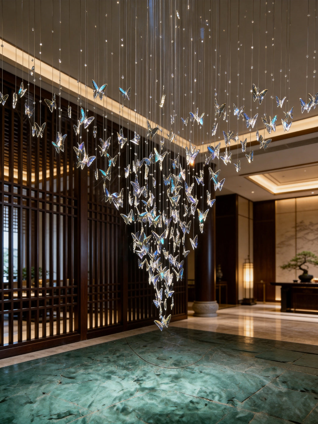Iridescent crystal butterfly chandelier suspended in a luxury hotel lobby with dark timber lattice screens and green marble flooring, Butterflies Custom Pendant by Lucretia