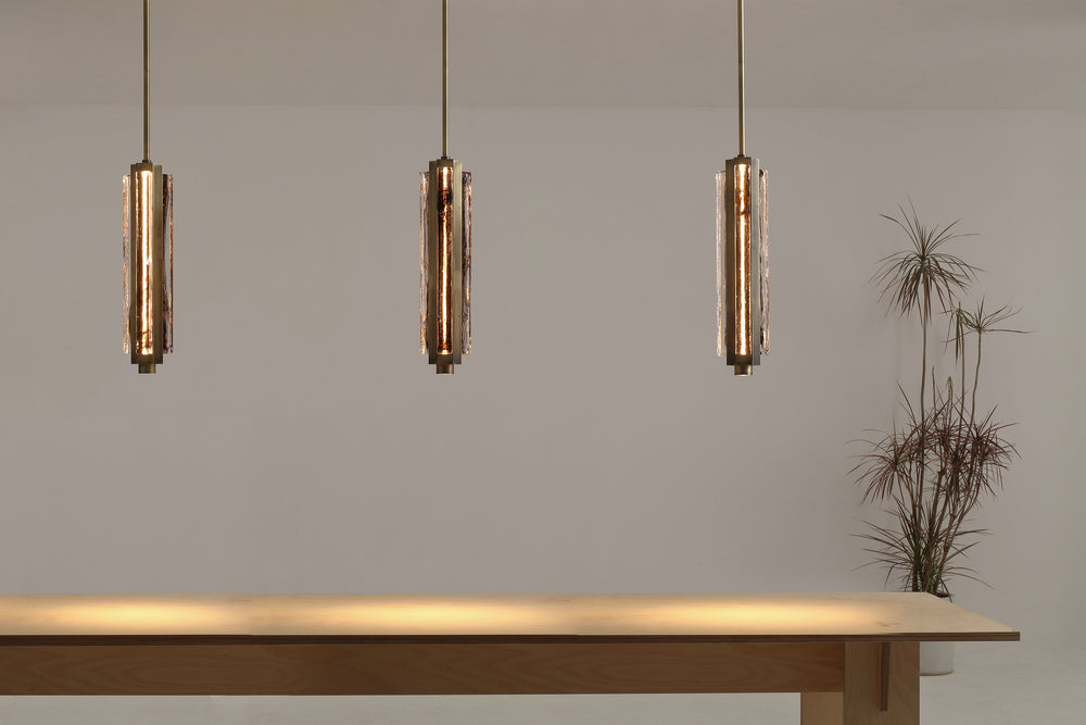 Hand-blown glass pendant lights over kitchen island, Running Water trio design creating warm ambient lighting