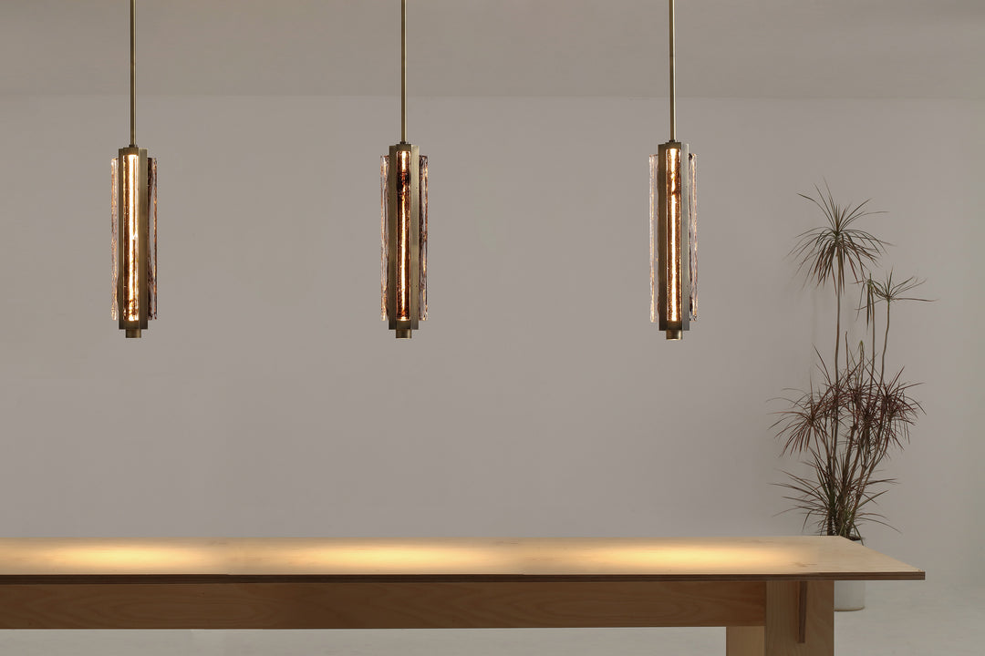 Hand-blown glass pendant lights over kitchen island, Running Water trio design creating warm ambient lighting