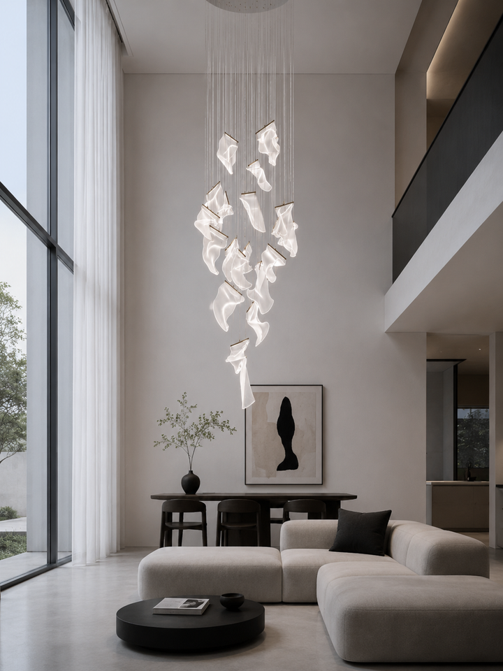 Large-scale sculptural acrylic void chandelier in a double-height open plan living room with floor-to-ceiling glazing, modular sofa and abstract artwork, Silken Chandelier 28 by Lucretia