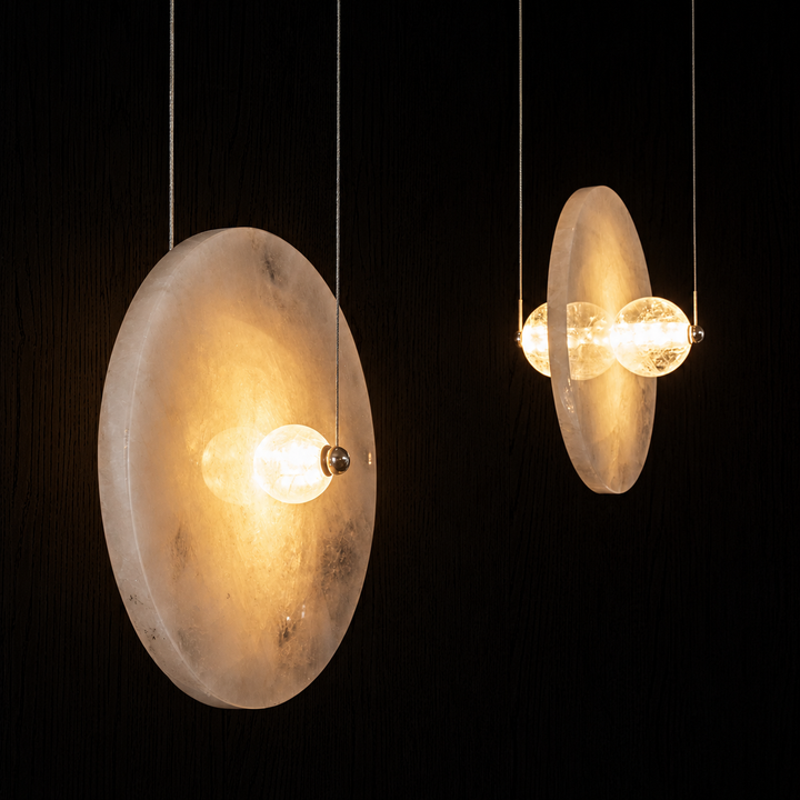 Luxury Earth Eclipse stone pendant light installation with hand-polished natural stone and illuminated crystal spheres.