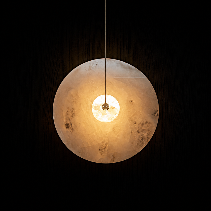 Earth Eclipse natural stone pendant light with illuminated crystal sphere for luxury residential and architectural interiors.