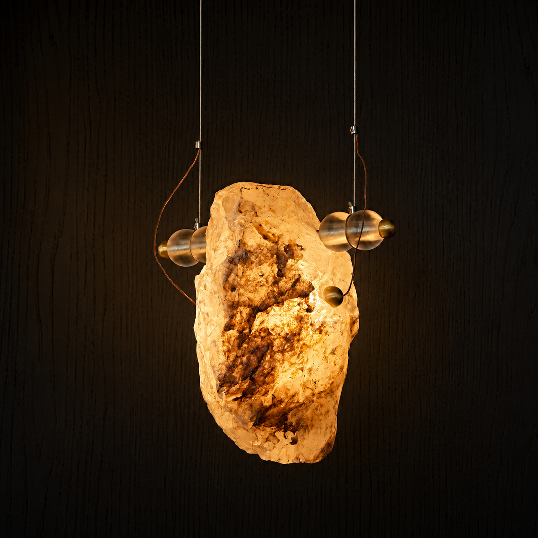 Earth Sculpture natural Brazilian crystal pendant light featuring a sculptural solid brass frame and raw crystal illuminated from within.
