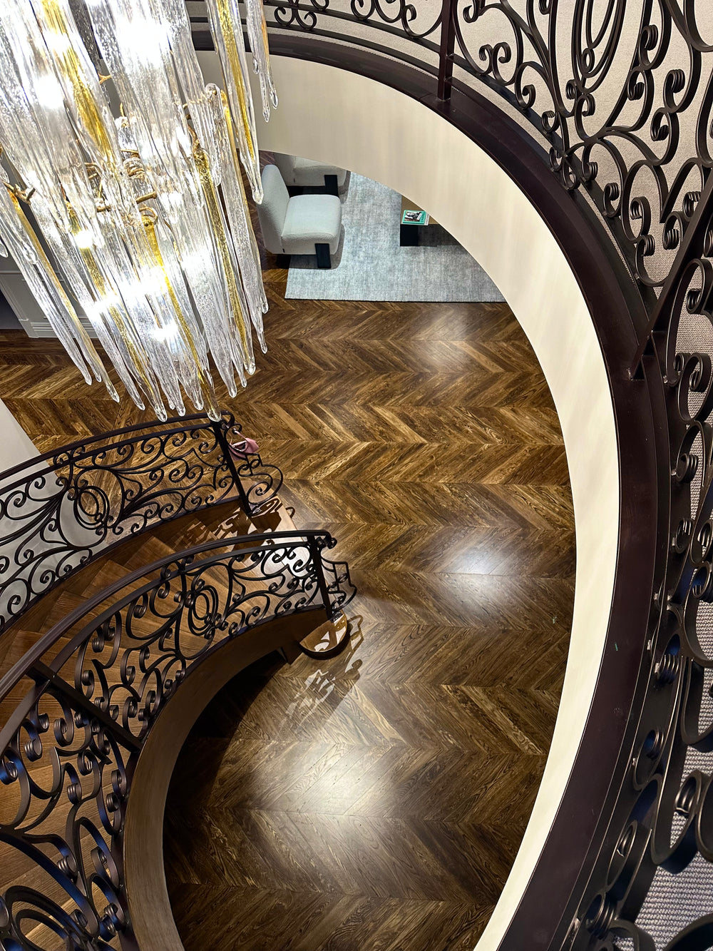 Top view installation of Lucretia Glacier 3 tier brass chandelier with long icicle crystal drops in a luxury staircase void interior