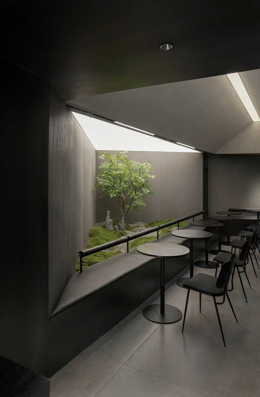 Lucretia hospitality stretch ceiling providing soft illumination in a dining room with feature greenery.