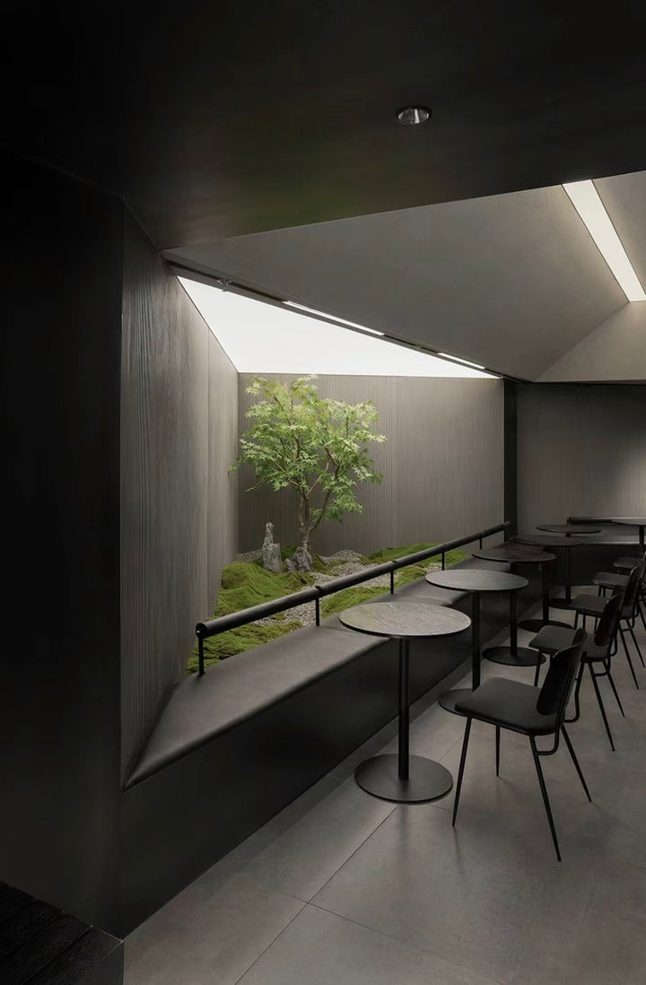 Lucretia hospitality stretch ceiling providing soft illumination in a dining room with feature greenery.