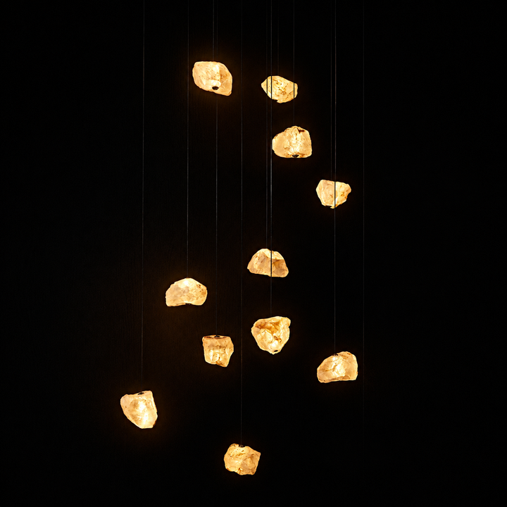 Aether Brazilian Natural Crystal Chandelier with 33 illuminated crystal pendants suspended against a minimalist black backdrop.