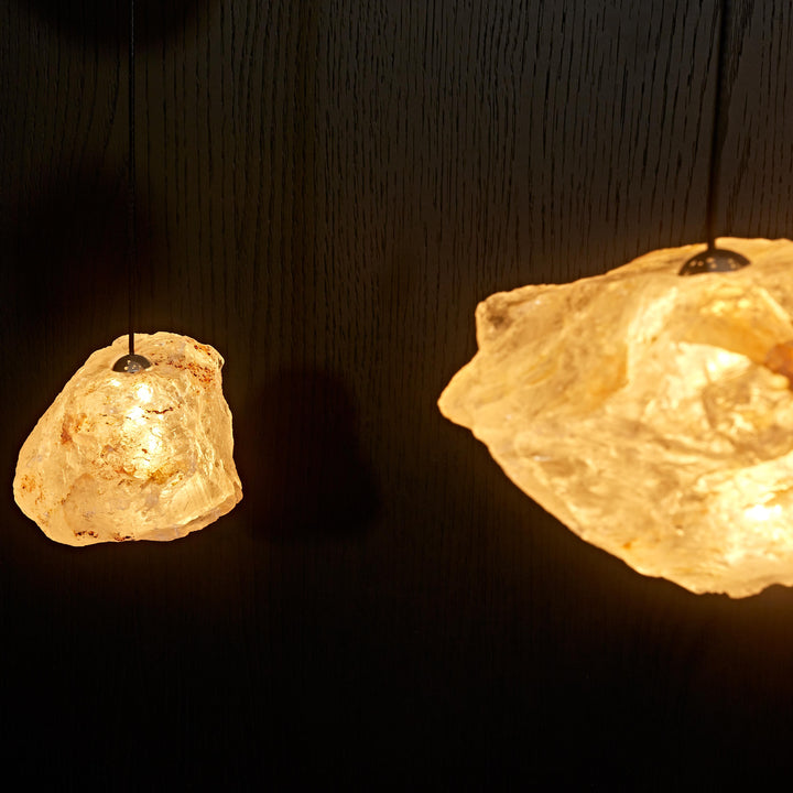 Detailed view of multiple Aether Brazilian Natural Crystal Pendant Lights with warm illumination and authentic raw crystal formations.