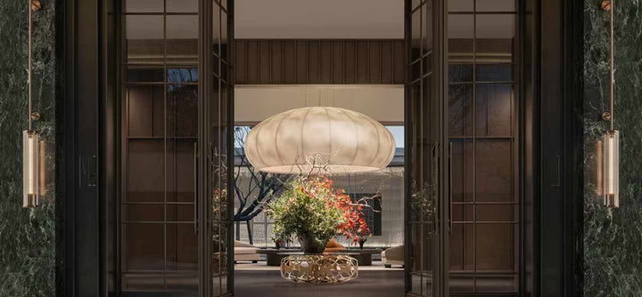 Lucretia Lighting Celestial Cloud bespoke pendant light viewed from outside a dining area showcasing luxury custom lighting and sculptural designer form