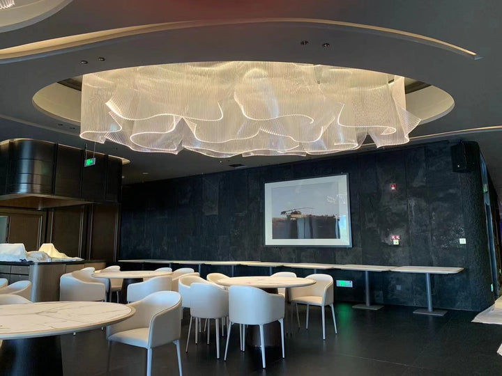 Lucretia Lighting infinity waves bespoke pendant light illuminating a luxury dining room with elegant custom lighting and flowing sculptural design