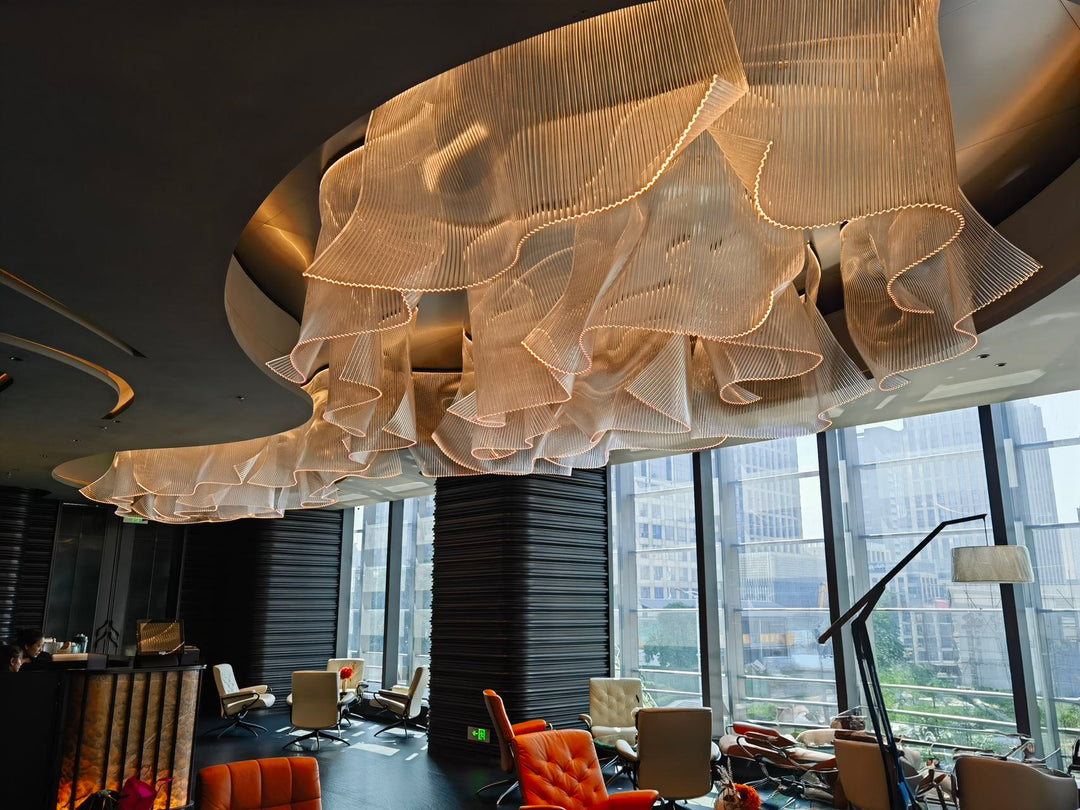 Lucretia Lighting infinity waves bespoke pendant light creating a sculptural luxury custom lighting feature across a hotel lobby with flowing wave-like design