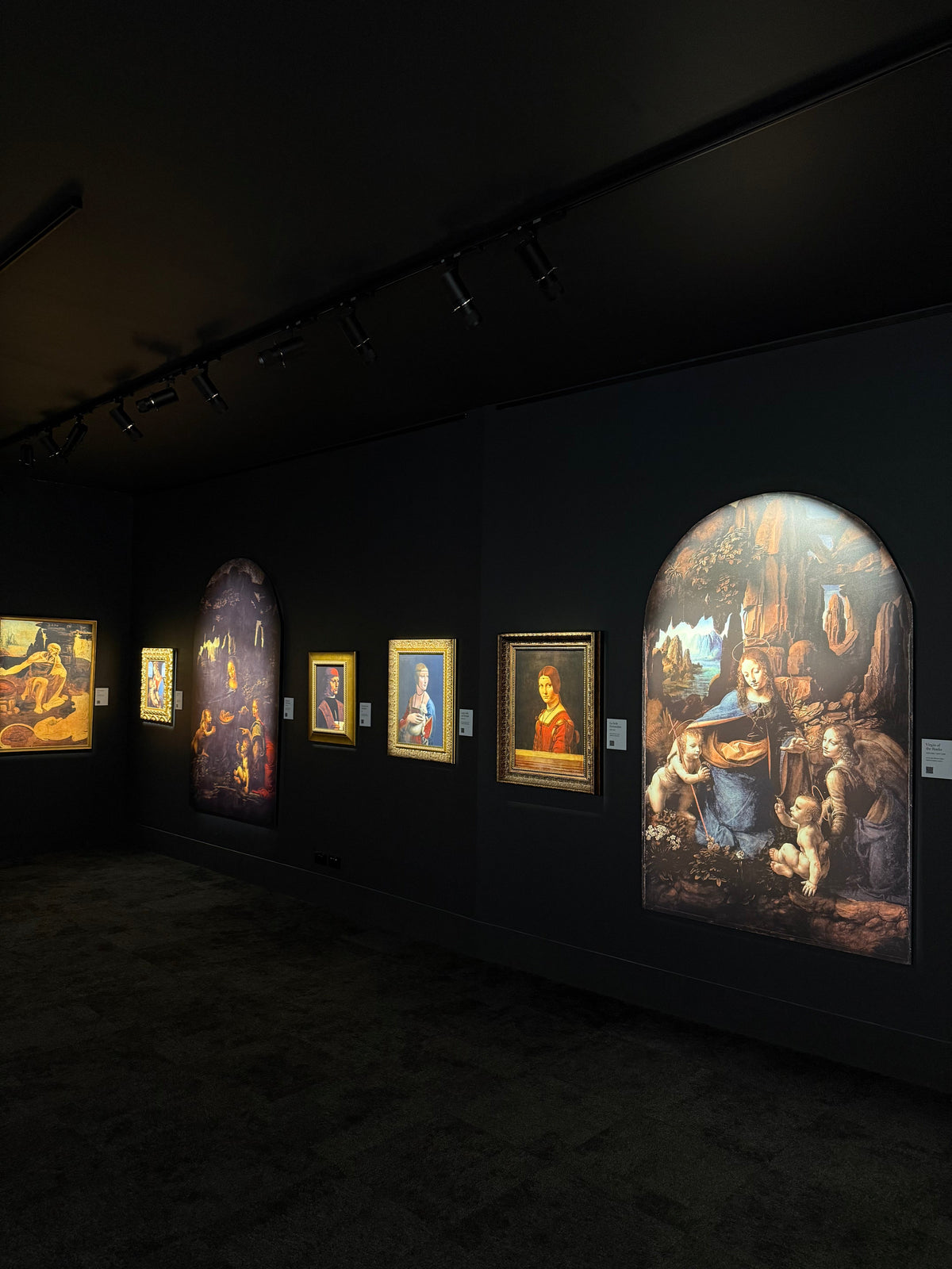 Lit panels along the walls of the darkened exhibition room at The LUME Melbourne