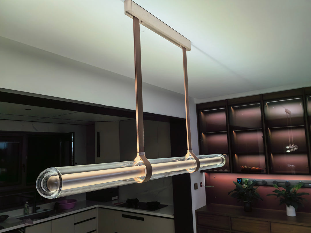LumiTube glass linear pendant with leather suspension straps creating warm designer lighting in a modern interior