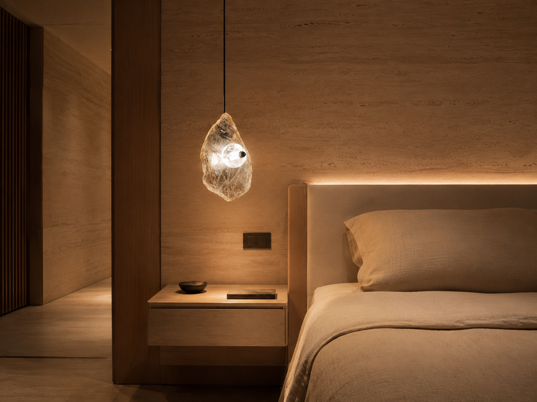 Luxury bedroom featuring the Frozen Earth natural Madagascar crystal pendant light with warm LED illumination in a contemporary residential interior.