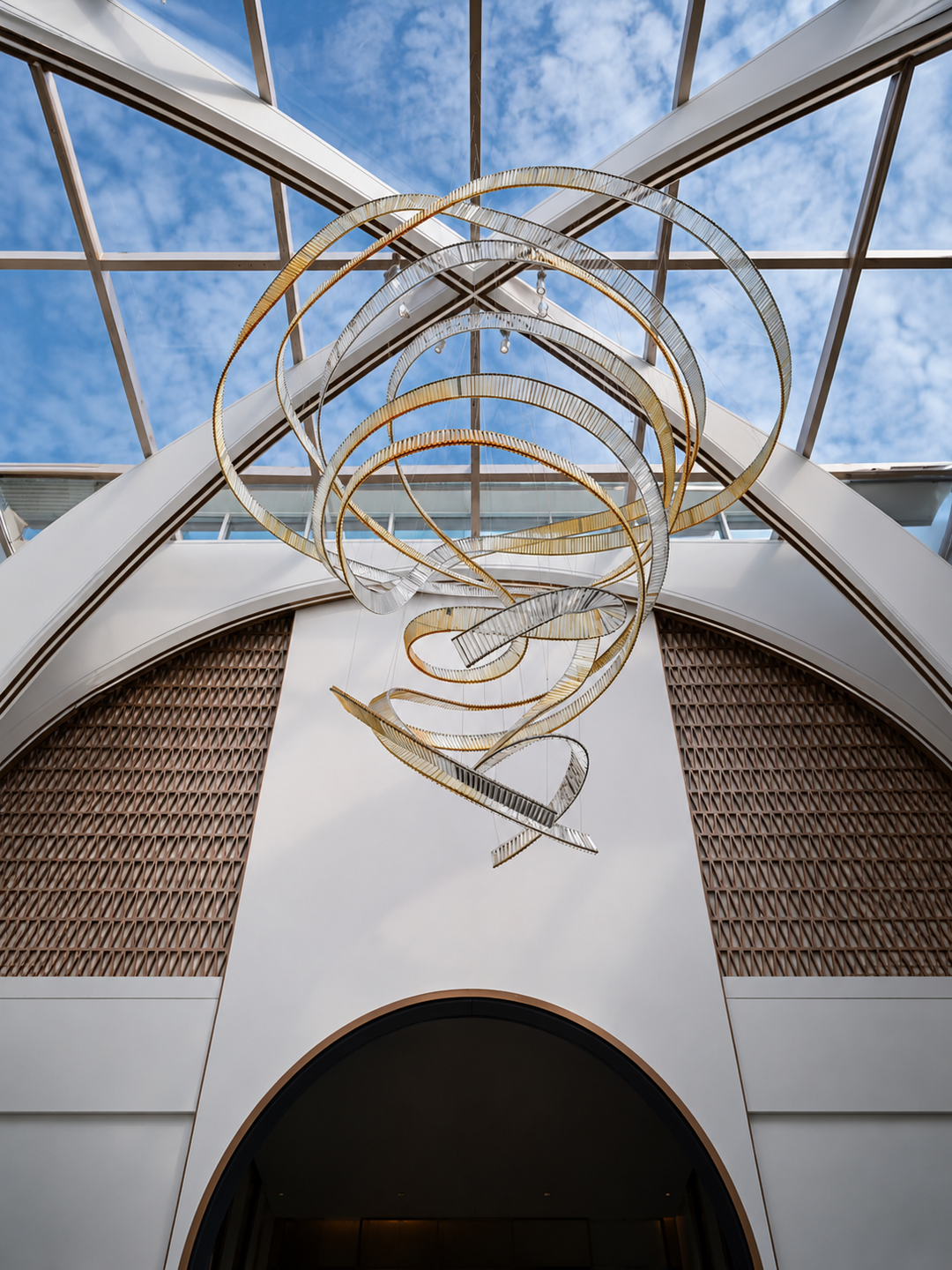Lucretia Lighting Pharaoh Infinity bespoke lighting shown as a sculptural crystal chandelier in a luxury atrium with custom fluid design under a skylight