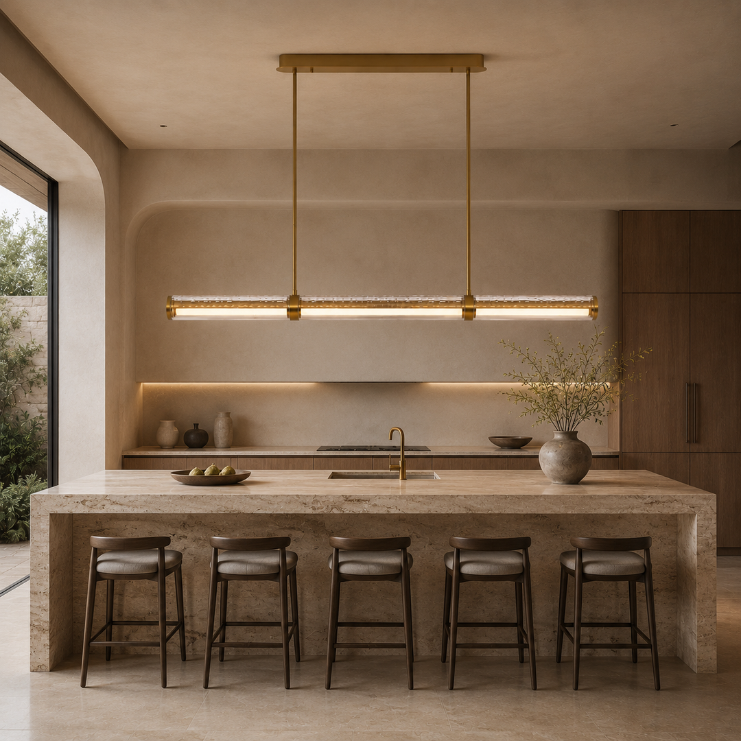 Prism Facet Linear Pendant Light above a natural stone kitchen island, featuring hand-crafted faceted European glass, brushed brass detailing and warm architectural LED lighting for luxury residential interiors.