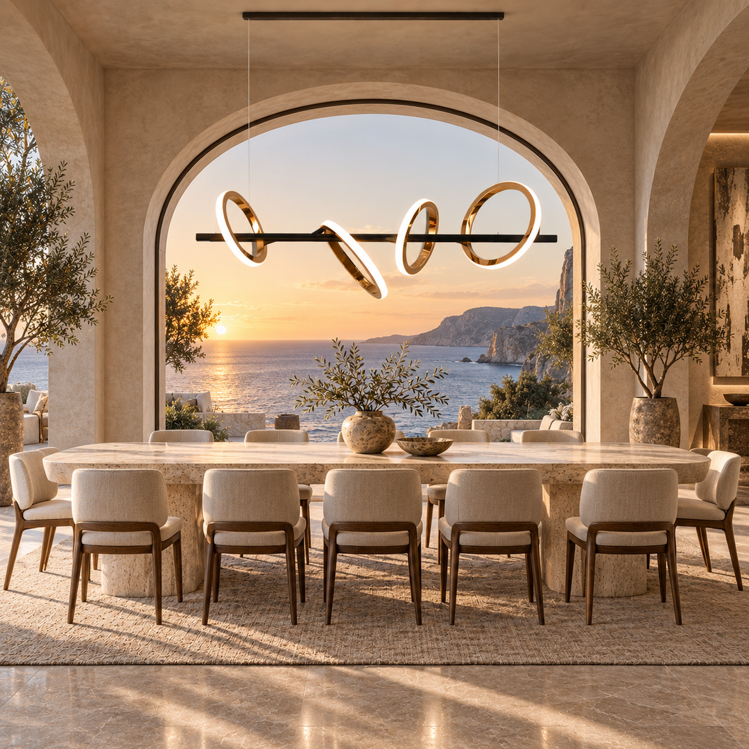 Soleil Custom 5A linear pendant light with rose gold rings above a travertine dining table framed by an arched sunset sea view